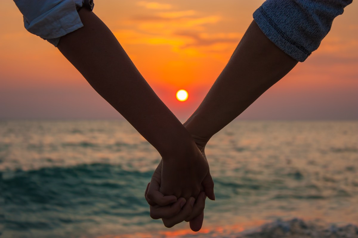 Couple Holding Hands at Sea Sunset